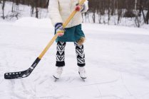 Vista de cerca de las piernas de una chica jugando hockey sobre hielo - foto de stock