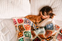Молода дівчина спить на ліжку з кішкою — стокове фото