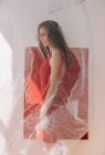 Portrait of a woman standing by a red wall behind a veil — Fotografia de Stock