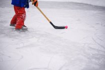 Visão de perto de um menino pernas jogando hóquei no gelo — Fotografia de Stock