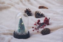 Decorazione natalizia con albero di Natale giocattolo e coni — Foto stock