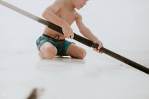 Niño sentado en un paddleboard, Condado de Orange, Estados Unidos - foto de stock