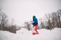 Niño construyendo un fuerte de nieve en el jardín - foto de stock