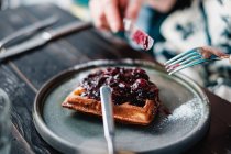 Closeup view of Woman eating waffles with jam — Stock Photo