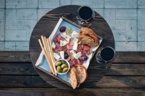Overhead view of antipasto and red wine on a table — Stock Photo