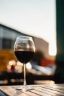 Склянка червоного вина на столі на заході сонця — стокове фото