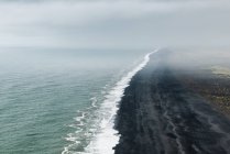Vista aérea de la playa Dyrholaey en la niebla, Islandia - foto de stock
