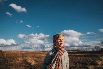 View of boy at autumn field under cloudy sky — Stock Photo