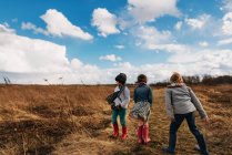 Счастливые дети на осеннем поле под облачным небом — стоковое фото