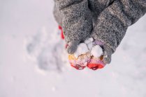 Overhead view of a girl's hands holding snow — Stock Photo