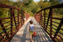 Tre bambini che attraversano un ponte — Foto stock