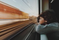 Ragazzo guardando attraverso la finestra del treno — Foto stock