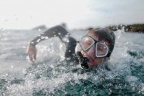 Garçon nageant dans l'océan portant un tuba et un masque, comté d'orange, États-Unis — Photo de stock
