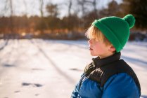 Портрет мальчика, играющего в снегу — стоковое фото