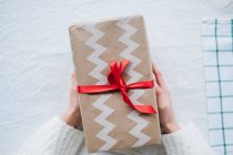 Cropped image of Woman holding a wrapped Christmas gift — Stock Photo