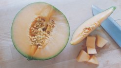 Vista de cerca de un melón picado sobre una mesa - foto de stock