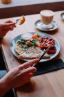 Frau isst ein Frühstück mit Ei und Speck — Stockfoto