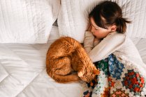 Jeune fille dormir sur le lit avec chat — Photo de stock