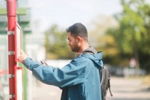 Man standing at a bus stop looking at the timetable, Germany — Stock Photo