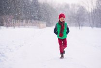 Ragazzo che cammina nella neve il giorno d'inverno — Foto stock