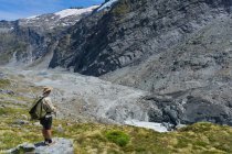 Randonneur surplombant le terminus du glacier Dart, vallée de la rivière Dart, parc national Mt Aspiring, île du Sud, Nouvelle-Zélande — Photo de stock