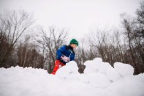 Junge baut im Garten eine Schneefestung über die Natur — Stockfoto