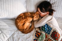 Giovane ragazza che dorme sul letto con gatto — Foto stock