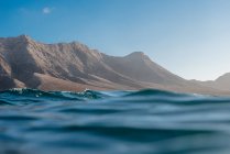 Прекрасный вид на горы над волнами моря — стоковое фото