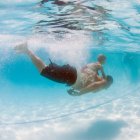 Мальчик плавает под водой со своим братом, округ Ориндж, Калифорния, США — стоковое фото