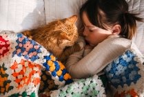 Junges Mädchen schläft auf Bett mit Katze — Stockfoto