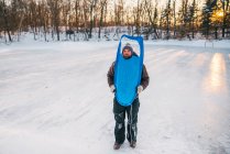 Homem de pé em um lago congelado olhando através de um trenó — Fotografia de Stock