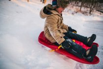 Close-up portrait of Boy sledging down a hill — Stock Photo