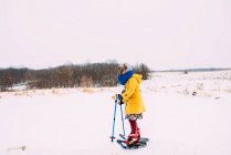 Menina snowshoeing na paisagem de inverno rural — Fotografia de Stock