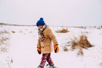 Boy walking in the snow wearing snowshoes — Stock Photo