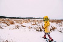 Ragazza che cammina sulla neve con le ciaspole — Foto stock