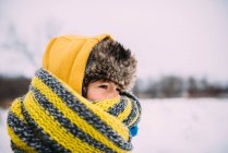 Портрет девушки, стоящей в снегу, завернутой в шляпу и шарф — стоковое фото