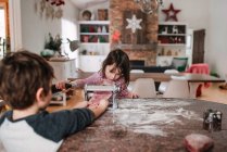 Мальчик и девочка стоят на кухне и делают макароны — стоковое фото