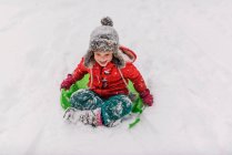 Jeune fille traîneau dans la neige lourde — Photo de stock
