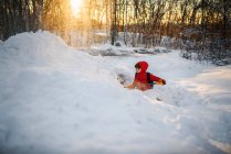 Мальчик убирает снег в саду — стоковое фото