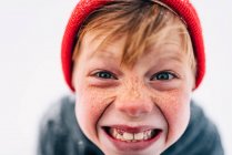 Portrait d'un garçon avec des taches de rousseur tirant des visages drôles — Photo de stock