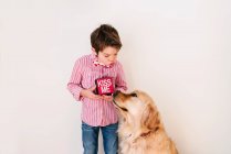 Boy blowing a kiss to his golden retriever dog — Stock Photo