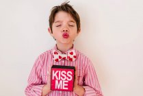 Smiling boy holding a Kiss me box — Stock Photo