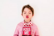 Souriant garçon tenant une boîte Embrasse-moi — Photo de stock