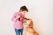 Garoto soprando um beijo para seu cão golden retriever — Fotografia de Stock