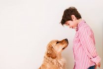 Boy looking at his golden retriever dog — Stock Photo