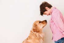 Boy looking at his golden retriever dog — Stock Photo