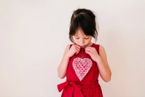 Chica sonriente sosteniendo una decoración en forma de corazón - foto de stock