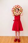 Menina segurando uma coroa do Dia dos Namorados na frente de seu rosto — Fotografia de Stock