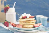 Pancakes with whipped cream and fresh strawberries — Stock Photo