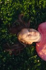 Menina sorridente deitada em um prado — Fotografia de Stock